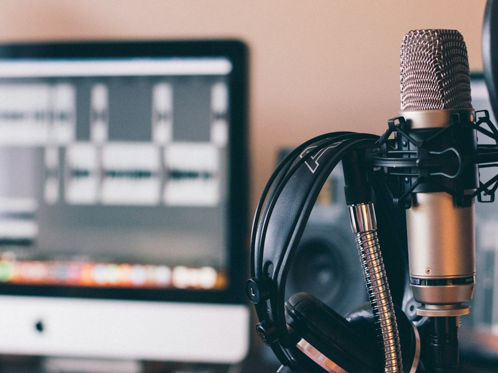 Un casque posé sur un micro de studio.